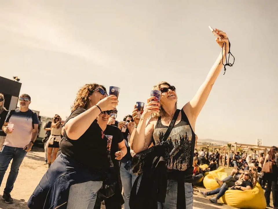 Public d'un festival levant ses gobelets Ecocup personnalisés